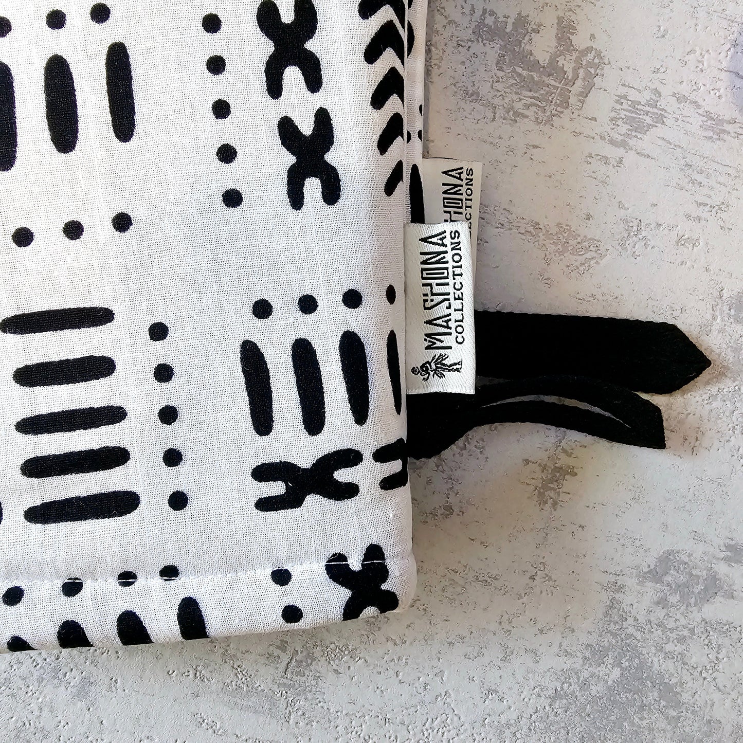 Black and white patterned product with a visible brand tag on a textured surface